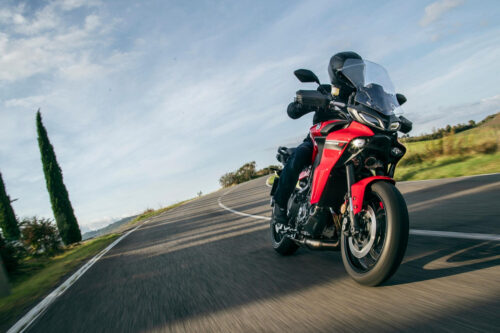 yamaha tracer 9 2021 europa visão frontal angular direita pilotando na estrada com campo aberto ao fundo